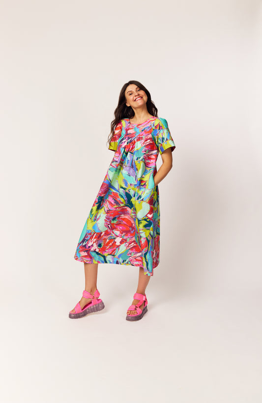 Lanya wearing JOY with The Debut Dress in the Protea Painterly print – sustainable floral midi dress with roomy pockets.