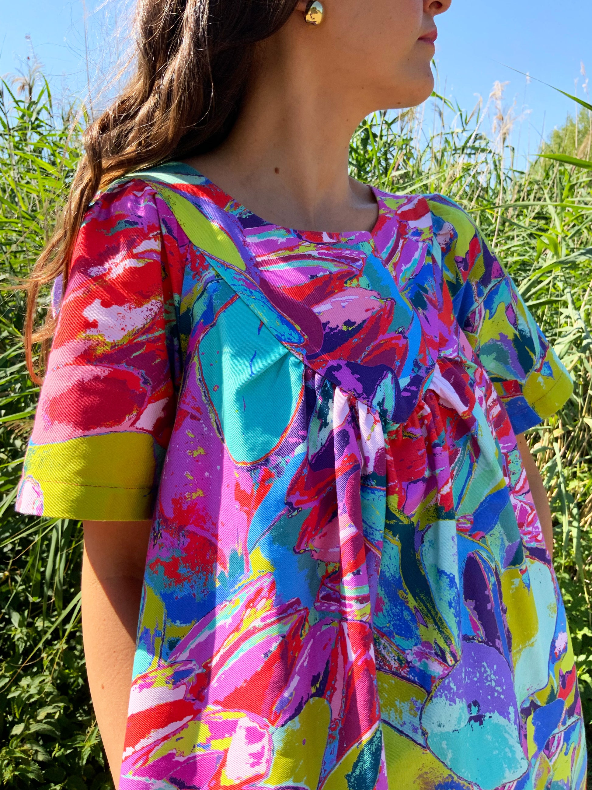 Close-up of Protea Painterly print Debut Dress ethical UK fashion – bold pink, green and turquoise brushstrokes on premium organic cotton, wearable work of art.